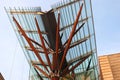 Modern V-shaped glass canopy with brown timber column and tree branches at John Niland Scientia Building on UNSW campus, Sydney