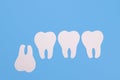 Inverted problematic wisdom tooth made of paper on a blue background