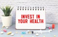 invest in your health advice or reminder - handwriting on an isolated sticky note, wellbeing concept