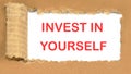 Invest in yourself the inscription appearing behind the torn cardboard paper Royalty Free Stock Photo