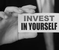 Invest in Yourself message on business card shown by a businessman. Education importance concept Royalty Free Stock Photo