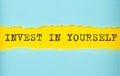 INVEST IN YOURSELF text on the torn paper , yellow background Royalty Free Stock Photo