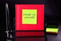 invest in yourself word on a yellow sticker on a red notebook. Concept photo Royalty Free Stock Photo