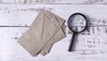 Investigating Confidential Mail: Magnifying Glass Analyzing Stack of Brown Envelopes Royalty Free Stock Photo