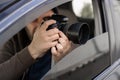 Investigator or private detective, reporter or paparazzi sitting in car and taking photo with professional camera Royalty Free Stock Photo