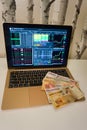 Investing African money bills spread out on laptop with stock market index screen Royalty Free Stock Photo