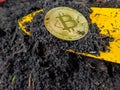 Investing in bitcoin and other cryptocurrencies mining by digging up the golden bitcoin from black soil with a shovel