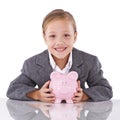 Investing in her future....Studio portrait of a young girl dressed like a businesswoman holding a piggybank. Royalty Free Stock Photo