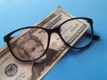 investment and promotion for a better vision, American banknote of twenty dollars and black plastic frame glasses Royalty Free Stock Photo