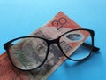 investment and promotion for a better vision, Australian banknote of twenty dollars and black plastic frame glasses Royalty Free Stock Photo