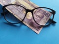 investment and promotion for a better vision, Honduran banknote of two lempiras and black plastic frame glasses Royalty Free Stock Photo