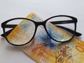 investment and promotion for a better vision, swiss banknote of ten francs and black plastic frame glasses