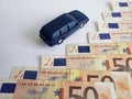 european banknotes and figure of a car in dark blue