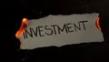Investment word written on white paper burns. Fire with smoke and ashes on black background Royalty Free Stock Photo