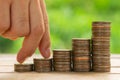 Investor business man finger walking on row of coins stack with blur green nature background. Money saving concept or Business Royalty Free Stock Photo