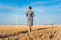 Investor in green energy looking at her wind turbines