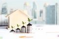 Investor of real estate.  The plants growing on money coin stack for investment home,  business newspaper with financial report on Royalty Free Stock Photo