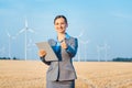 Investor in wind turbines with computer evaluating her investment Royalty Free Stock Photo