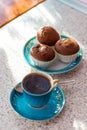 Invigorating cup of coffee with cupcakes is on the table for breakfast