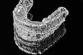 Invisible transparent dental removable braces on the black background. Orthodontic appliance for dental correction