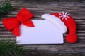 Invitation card on a wooden background with a Santa hat and feer tree