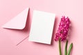 Invitation or greeting card mockup with envelope and spring hyacinth flowers on pink paper background Royalty Free Stock Photo