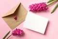 Invitation or greeting card mockup with envelope and spring hyacinth flowers on pink paper background Royalty Free Stock Photo