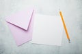 Invitation letter or postcard. An empty square piece of paper with space for text, a pink envelope and a pencil on a vintage white Royalty Free Stock Photo