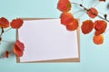 Invitation template with an envelope on a blue background with autumn red foliage on a branch. Royalty Free Stock Photo