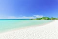 inviting beautiful view of tropical white sand beach and tranquil turquoise ocean on blue sky background
