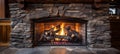 Inviting close up of rustic stone fireplace with roaring fire in charming log cabin Royalty Free Stock Photo