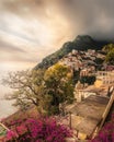 Inviting pathway lined with bright pink flowers against an urban backdrop in Positano Italy