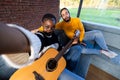 Cozy Musical Moment: Friends with Guitar in a Sunny Room Royalty Free Stock Photo