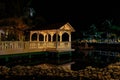 Inviting view of Memories Caribe hotel grounds with cozy gazebo lighted with various warm lights, reflected in water at evening ti