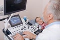 Involved aging practitioner using sonography equipment at work