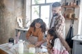 Curly cute girls feeling involved in cooking with daddy