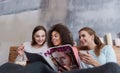 Involved friends reading and discussing the magazine at home Royalty Free Stock Photo