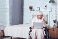 Involved handicap aging woman using laptop at home