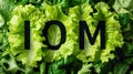IOM Text on a Bed of Fresh Green Leafy Vegetables Royalty Free Stock Photo
