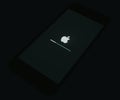 iOs loading at the Apple iPhone Black start screen, isolated in darkness