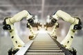 Iot industry 4.0 technology concept.Smart factory using trending automation robotic arms with part on conveyor belt in operation l