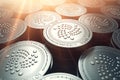 IOTA coins in blurry closeup with sunburst from above. IOTA growth concept. Royalty Free Stock Photo