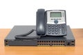 IP phone and networking switch on wood table