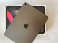 The iPad Air 2020 tablet in black color lies on a branded box on a white isolated background. Back side view of the tablet Royalty Free Stock Photo