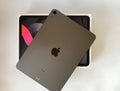 The iPad Air 2020 tablet in black color lies on a branded box on a white isolated background. Back side view of the tablet Royalty Free Stock Photo
