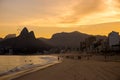 Sunset at Ipanema beach with people relaxing & paraglider in sky with Dois IrmÃÂ£os Two Brothers mountains in background Royalty Free Stock Photo