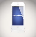 Iphone 5 device, showing the Facebook logo.