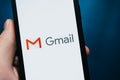 Hand holding iPhone with Gmail app logo on the screen. Royalty Free Stock Photo