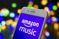 An iPhone Plus with a Amazon Music logo on the screen