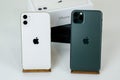 IPhone 11 Pro Max in midnight green and iPhone 11 in white side by side.